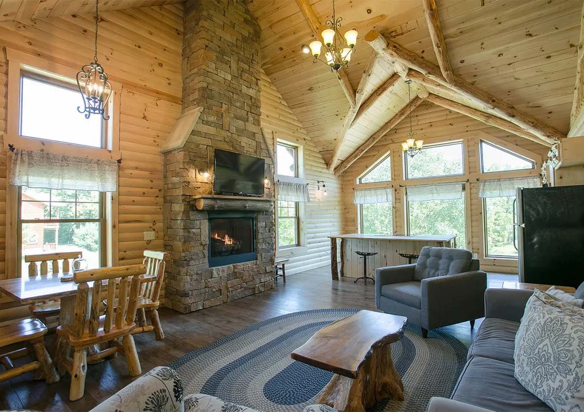 Cabin living room with warm wood interiors overlooking the pond